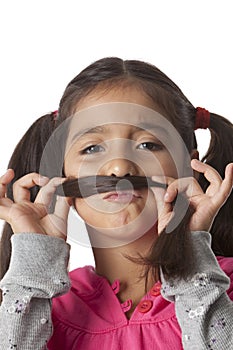 Little girl is making a moustache of her hair