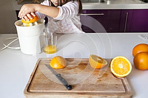 Little girl making orange juice