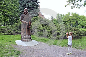 Girl making photo on phone monument to Ilya Muromets Slavonic fairy-tale hero photo
