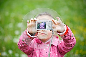 Little girl making a selfie with digital camera