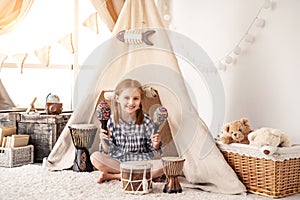 Little girl with maracas and djembe drums