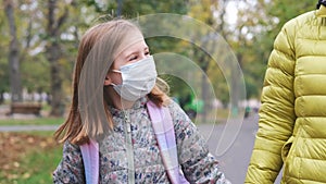 Little girl in mask going to school