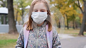 Little girl in mask walking in park