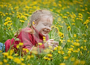 Little girl and meadow with dandelions. Summer day, outdoors