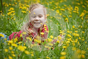 Little girl and meadow with dandelions. Summer day outdoors