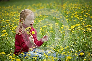 Little girl and meadow with dandelions. Summer day outdoors