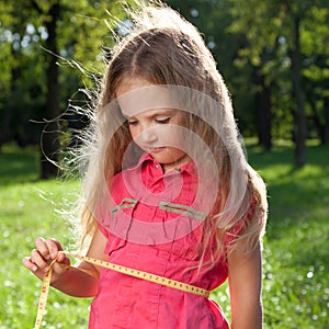 Little girl measuring her waist