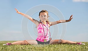 Little girl with medals sitting on the splits on