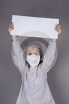 Little girl in medical mask is holding blank white poster
