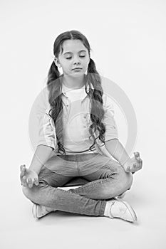 Little girl meditate sitting on penny board on yellow background. Time for yoga. Hipster child activity. Concentration
