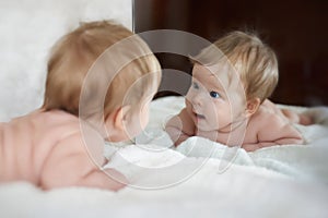Little girl met a new friend in the mirror reflect