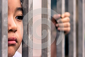Little girl with metal fence, feeling no freedom.
