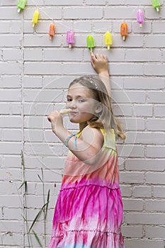 Little girl with mischievous expression touching popsicle String Lights garland