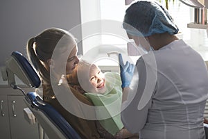 Little girl with mommy in dentist room - conversation with doctor