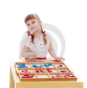 Little girl in a Montessori kindergarten is