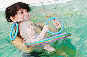 Little girl and mothe in swimming pool