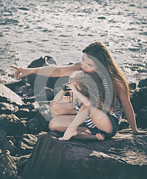 Little girl and mother looking far away with binoculars