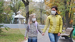 Little girl with mother in masks walking