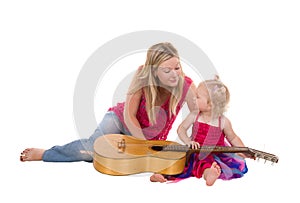 Little girl with mother playing guitar