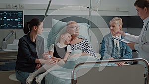 Little girl and mother visiting grandpa in hospital ward