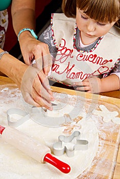 Little girl with mum baking Christmas cookies