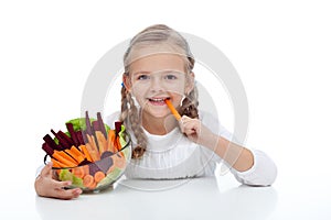 Little girl munching on a carrot stick