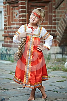 Little girl in national costumes in Russian village