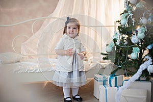 Little girl near Christmas tree with presents rejoices holiday, new year, decorations, gift, box, holiday, lifestyle