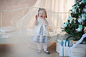 Little girl near Christmas tree with presents rejoices holiday, new year, decorations, gift, box, holiday, lifestyle