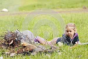 Little girl near fire camp