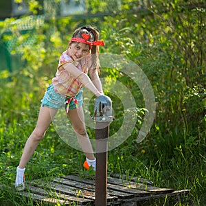 Little girl near the water pump in the village.