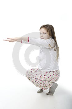 Little girl in nightwear warm-up on white