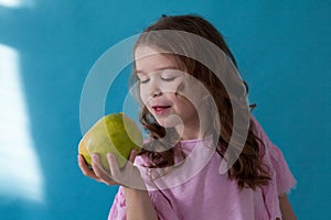 Little girl with no teeth eats fruit apple