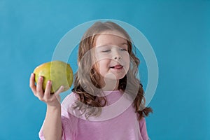 Little girl with no teeth eats fruit apple