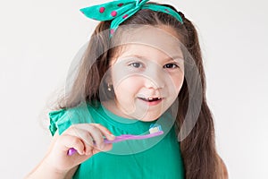 Little girl with no teeth with a toothbrush in dentistry