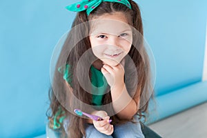Little girl with no teeth with a toothbrush in dentistry