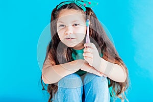 Little girl with no teeth with a toothbrush in dentistry