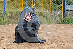 A little girl obscures her face with a hand written in black marker HELP, offended children