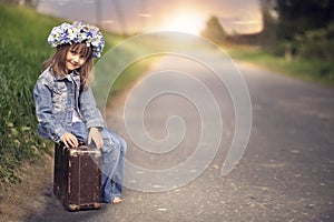 A little girl with an old suitcase