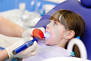 Little girl with open mouth receiving dental filli