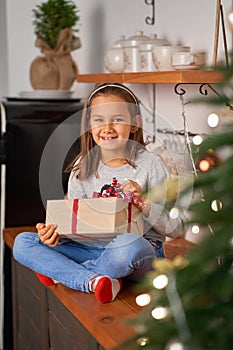 Little girl opens a box with a Christmas present from Santa