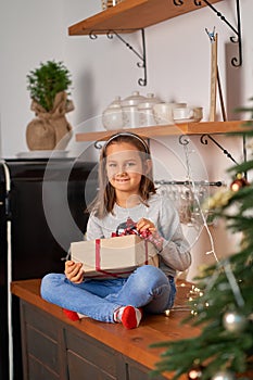 Little girl opens a box with a Christmas present from Santa