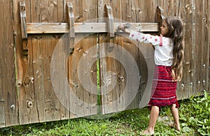 Little girl opens the gate