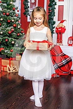 A little girl opens a gift box. Concept New Year, Merry Christma