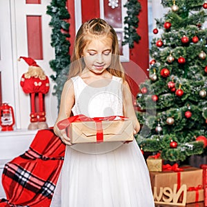 A little girl opens a gift box. Concept New Year, Merry Christma