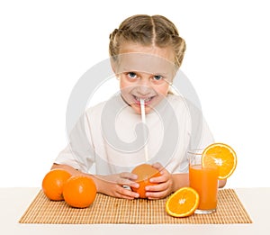 Little girl with oranges drink juice with a straw