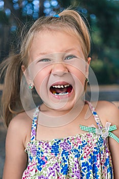 Little girl with orthodontics appliance and crooked teeth. Wobbly tooth