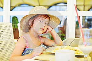 Little girl  in outdoor cafe