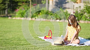 Little girl outdoors in the park with computer