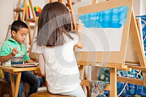 Little girl painting a landscape